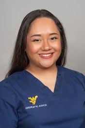 Katrina Roxas wearing dark blue WVU School of Nursing scrubs.